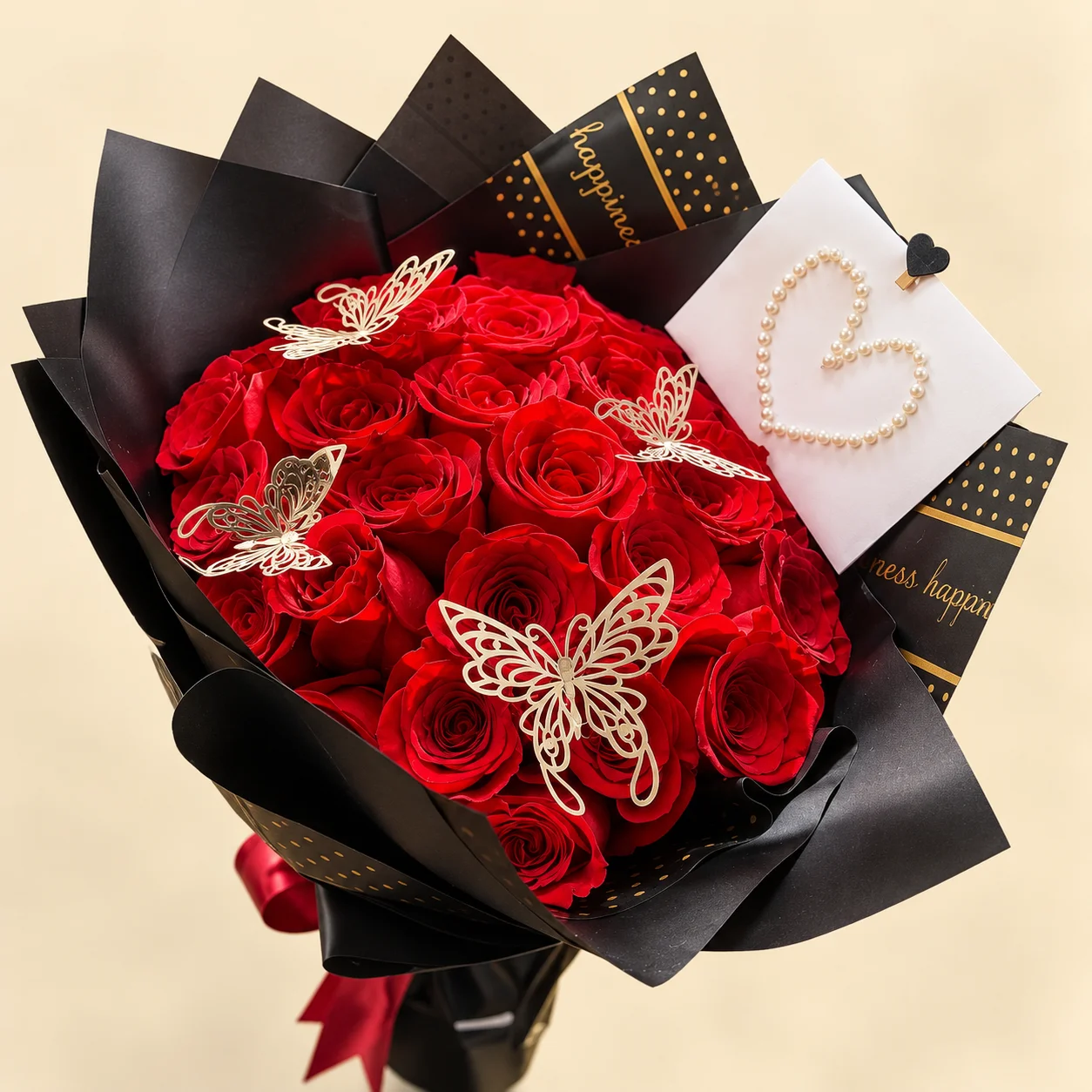 Alas de Pasión - 25 rosas rojas en papel negro con mariposas doradas y tarjeta